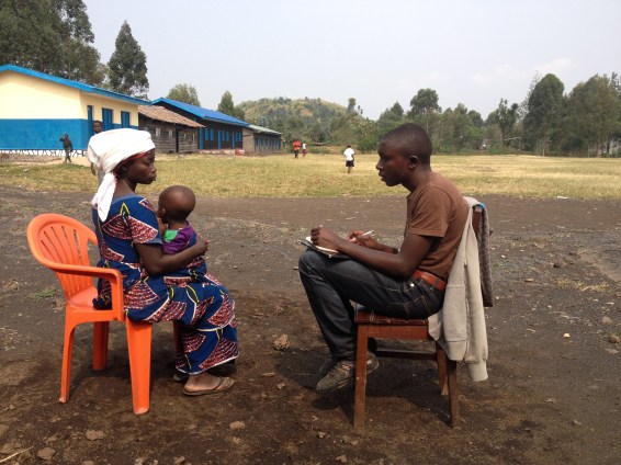 Arsene talking to one of our beneficiaries to learn about her story